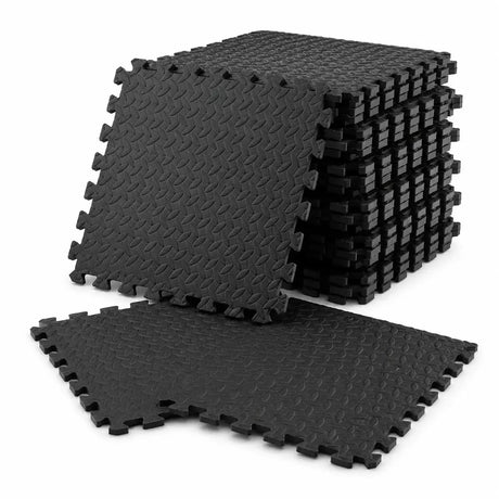 A stack of black interlocking foam floor mats with a textured diamond pattern, shown on a clean white background.