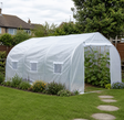 4.5 x 3 metre white polytunnel greenhouse set up in a UK back garden with flower borders and stepping stones
