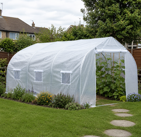 4.5 x 3 metre white polytunnel greenhouse set up in a UK back garden with flower borders and stepping stones